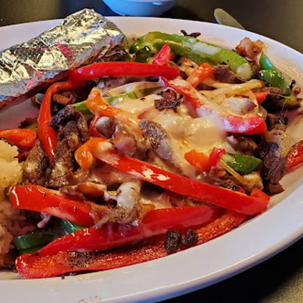 Itacate Mexican Food's fajitas with steak, red and green bell peppers, onions, and melted cheese.